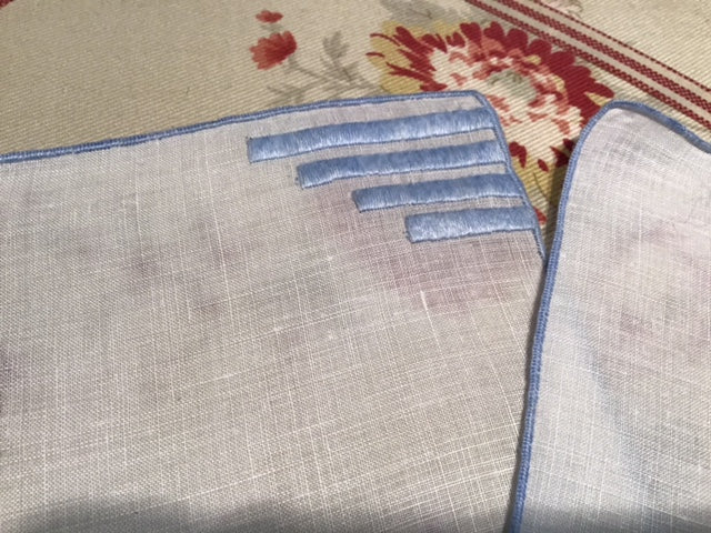 4 white linen cocktail napkins with light blue embroidery